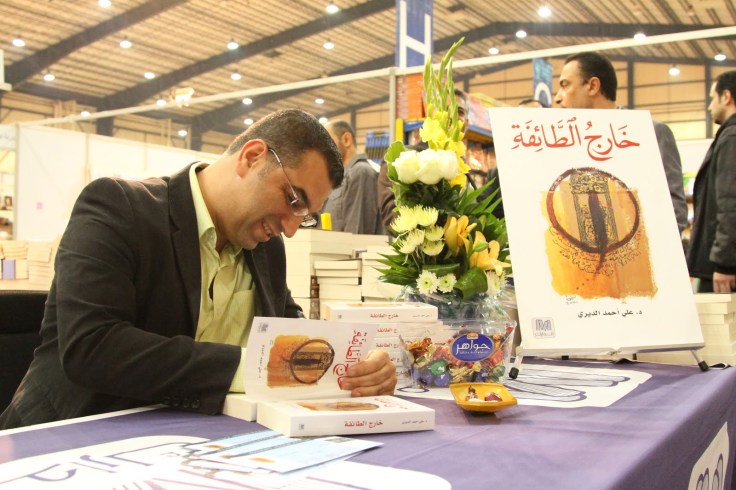 الديري يوقع أحد كتبه في معرض للكتاب